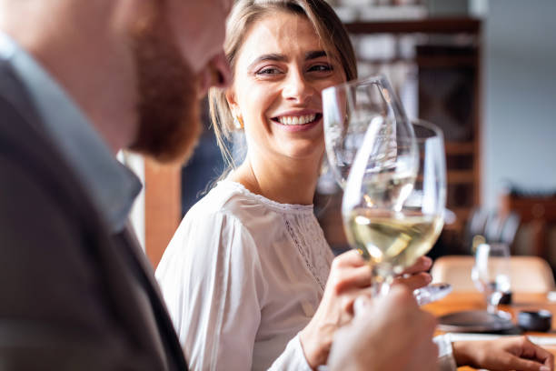 istock Two cheerful colleagues raising white wine glasses 1051749368