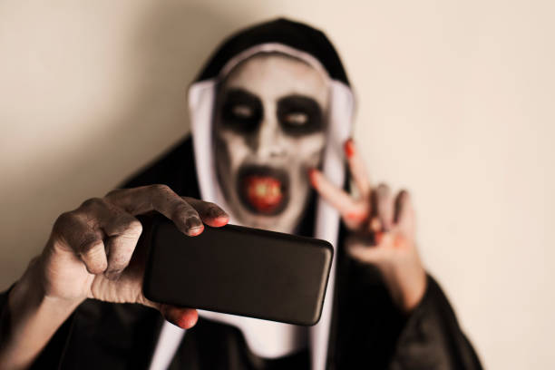 frightening evil nun taking a selfie - bad habit imagens e fotografias de stock