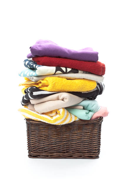 istock Clothes in a laundry wooden basket isolated on white background 1051754224