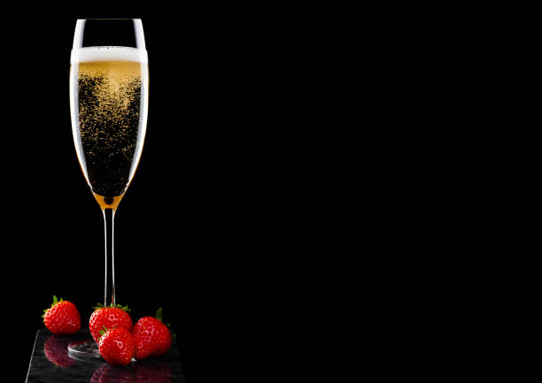 黒の背景に黒の大理石ボードに新鮮なストロベリーとシャンパンを黄色のエレガントなガラス。テキストのためのスペース - champagne celebration glass black ストックフォトと画像