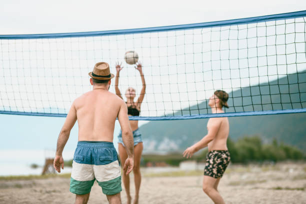 istock Group Of Friends Playing Beach Volleyball 1051762528