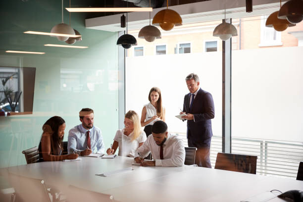 istock Group Collaborating On Task At Graduate Recruitment Assessment Day Whilst Being Observed By Recruitment Team 1051764142
