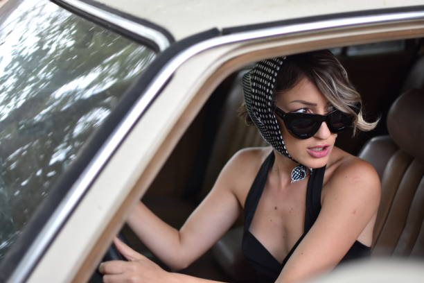 istock stylish woman model in a retro car 1051773558