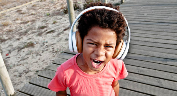 istock Young Boy Wearing A Headphone Posing On A Wooden Pier/Bridge 1051777056