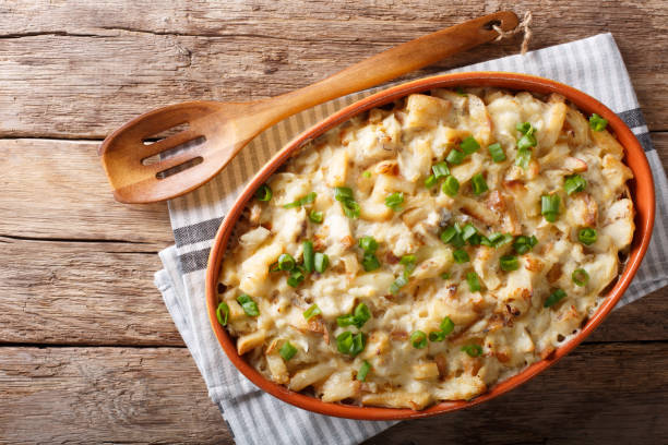 portuguese food: casserole with cod, potatoes, onions and cream in a baking dish close-up. horizontal top view - bacalhau imagens e fotografias de stock