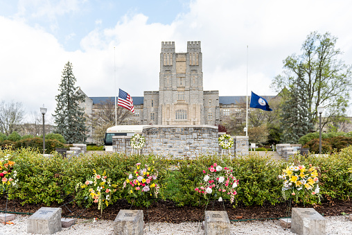 Blacksburg, USA - April 18, 2018: Historic Virginia Tech Polytechnic Institute and State University College campus with Burruss hall facade exterior and memorial flowers