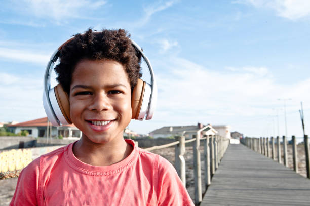 istock Young Boy Wearing A Headphone Posing On A Wooden Pier/Bridge 1051777728