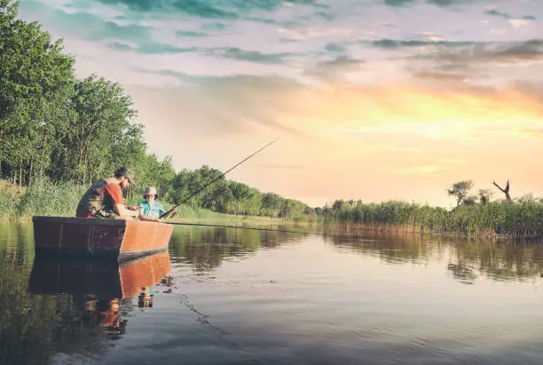 Photo of Dad and son fishing from a boat