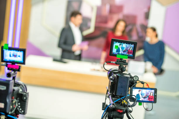 Cameras filming a television talk show Rear view of two cameras filming a television talk show. stage set stock pictures, royalty-free photos & images