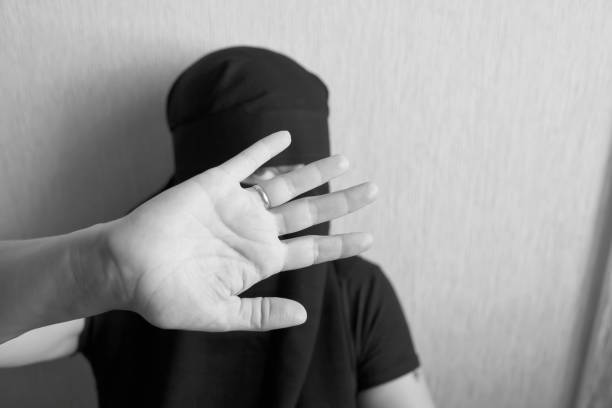 istock Woman in niqab holds her head with her hands 1051797918
