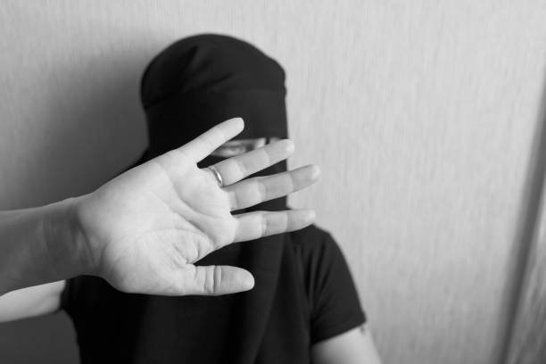 istock Woman in niqab holds her head with her hands 1051797988