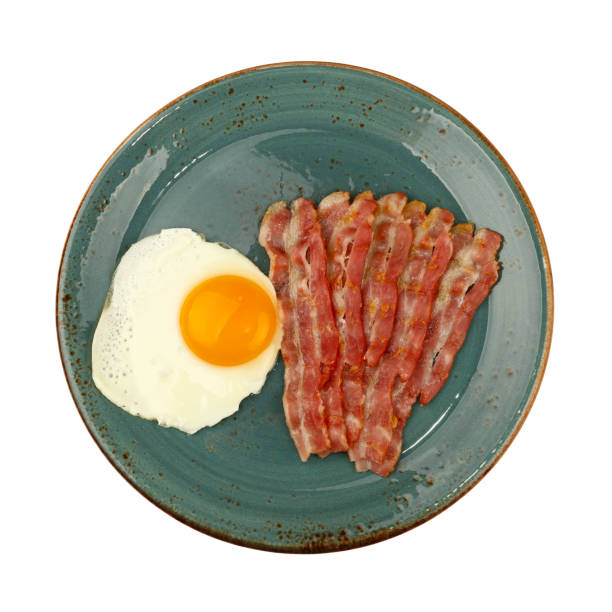 istock Close up sunny side egg and bacon on blue plate 1051798762