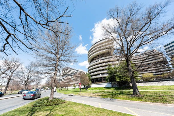 Watergate hotel building exterior in capital city, residential building architecture, spring springtime, bare trees in park Washington DC, USA - April 5, 2018: Watergate hotel building exterior in capital city, residential building architecture, spring springtime, bare trees in park hotel watergate stock pictures, royalty-free photos & images