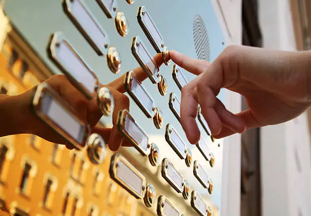 finger on golden doorbells with blank name plates