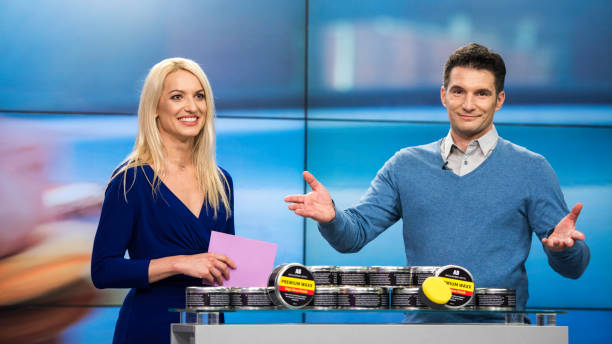 TV show co-hosts presenting premium wax product on TV A blonde woman and brown-haired man presenting a wax product in a can on a TV show. television host stock pictures, royalty-free photos & images