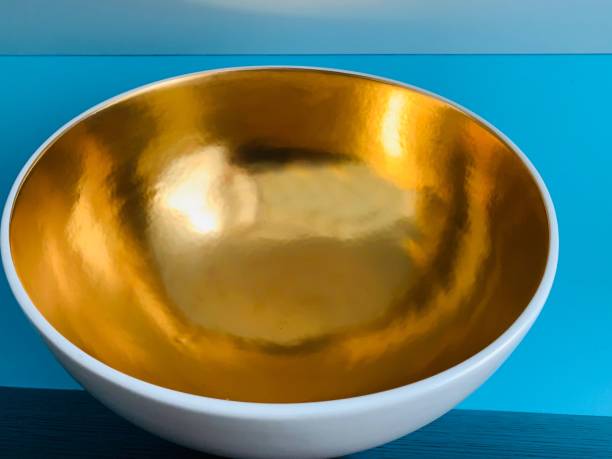 Golden bowl from above on blue background