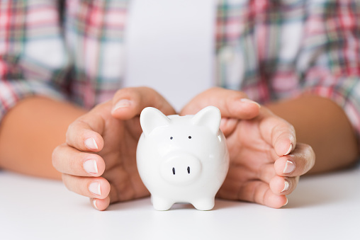 Woman hand holding piggy bank. Saving money wealth and financial concept.