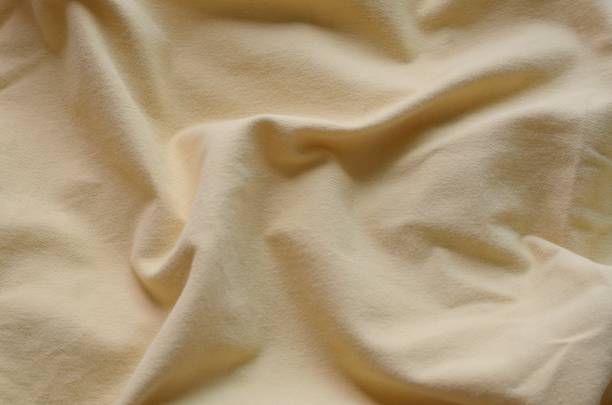 istock Top view of messy yellow color bed sheet texture background. 1051827266