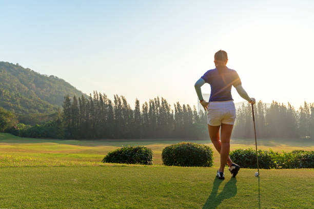 golf kobiety.  wesoła szczęśliwa azjatka uśmiechnięta kobieta z grą w golfa w klubie golfowym w słonecznym i wieczornym czasie zachodu słońca, kopiuj przestrzeń. koncepcja stylu życia - teeing off zdjęcia i obrazy z banku zdjęć