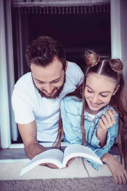 istock Father Reading Funny Story To Daughter 1051839462