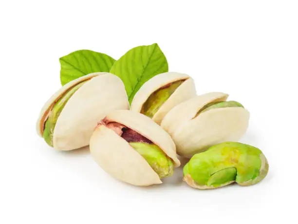 Photo of Pistachios with leaves isolated on white background