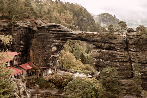 pravcicka puerta (arco natural más grande de europa), checa-saxon suiza, república checa. paisaje brumoso bosque de abeto en estilo retro vintage hipster - pravcicka fotografías e imágenes de stock