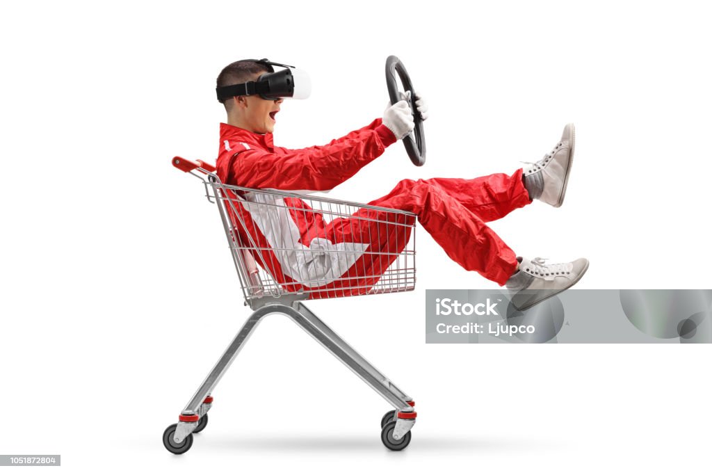 Adolescente em uma roupa de corrida com VR googled segurando um volante dentro de um carrinho de compras - Foto de stock de Carro royalty-free