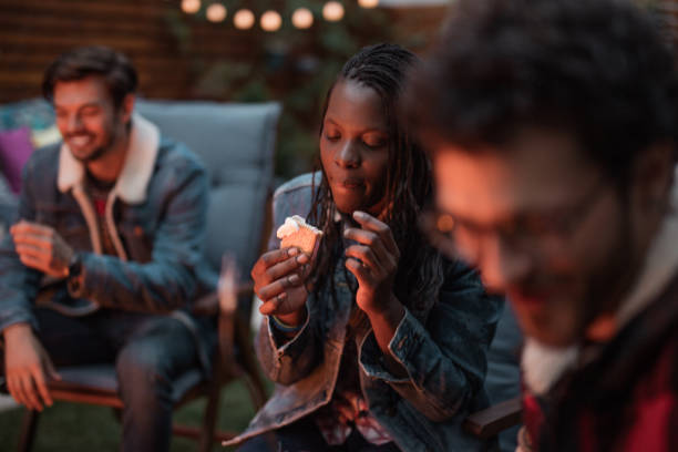 Millennial woman eating s'mores Millennial woman eating s'mores smore photos stock pictures, royalty-free photos & images