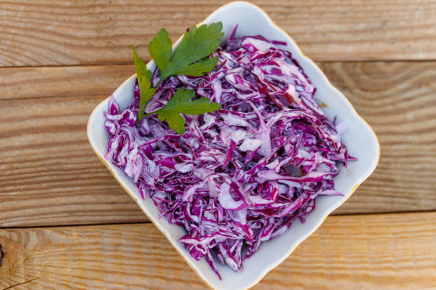 istock Red cabbage salad with onion and mayonnaise on wooden table. Top view 1051909462