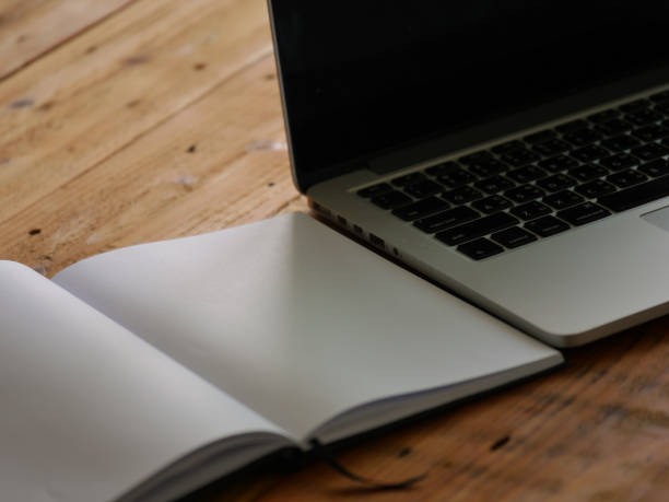 istock notebook and laptop on wooden table 1051950876