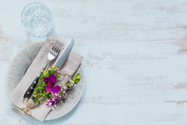 istock Rustic table setting with purple flowers on light wooden table. 1051954250