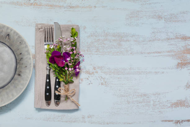 istock Rustic table setting with purple flowers on light wooden table. 1051954428