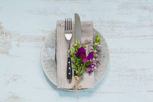 istock Rustic table setting with purple flowers on light wooden table. 1051954474