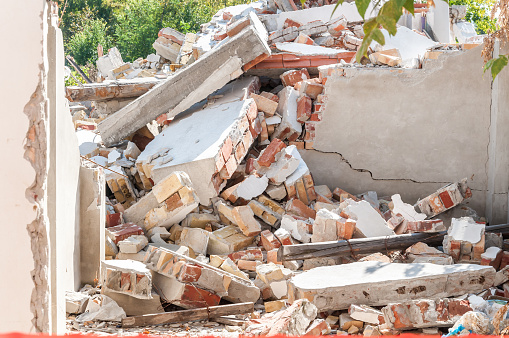 Restos de daños de desastres huracán o terremoto en ruina antigua casa con techo derrumbado y las paredes de la pila photo