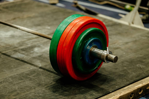 istock barbell with green and red plates on platform for powerlifting 1051960884