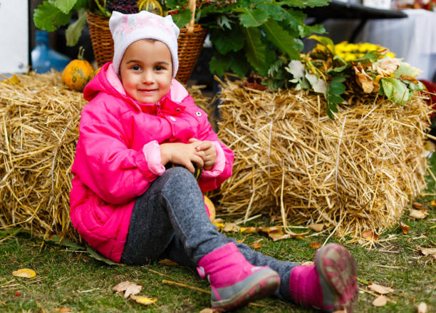 ritratto di una bambina con verdure vicino al fieno - marrow squash autumn corn crop hay foto e immagini stock