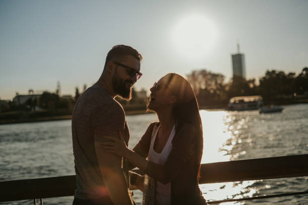 istock Couple laughing by the river in the sunset 1051969272