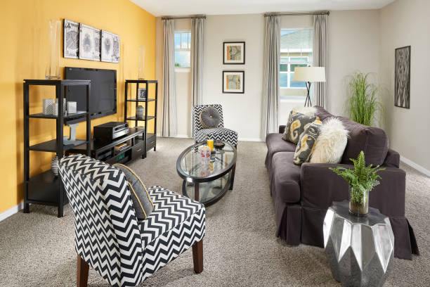 A Yellow, Black, and Grey Living Room with a Purple Couch in a Model Home stock photo