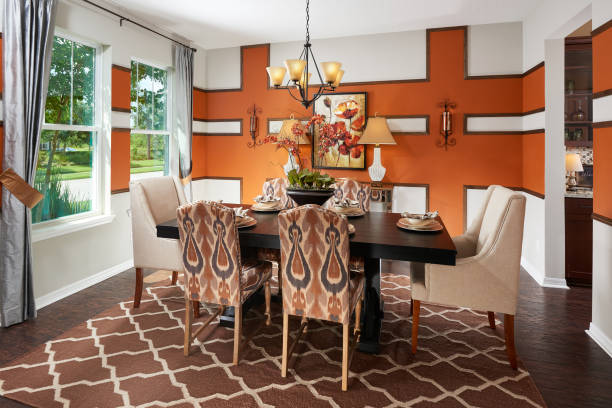 An Orange, Brown, and White Dining Room with an Intricate Accent Wall in a Model Home stock photo