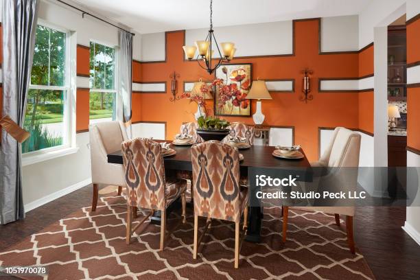 An Orange Brown And White Dining Room With An Intricate Accent Wall In A Model Home Stock Photo - Download Image Now
