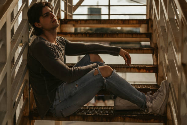 istock Man sitting alone on the staircase and looking far away 1051970080