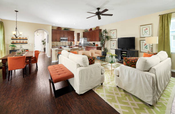 A Green, Orange, and Brown Great Room with a Green and White Area Rug in a Model Home stock photo