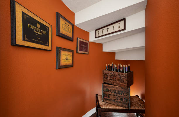 An Orange, White, and Brown Wine Storage under the Staircase in a Model Home stock photo