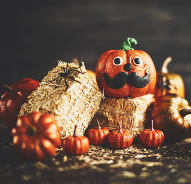 istock Pumpkin gentleman character with handmade features and monocle on straw bales 1052006284