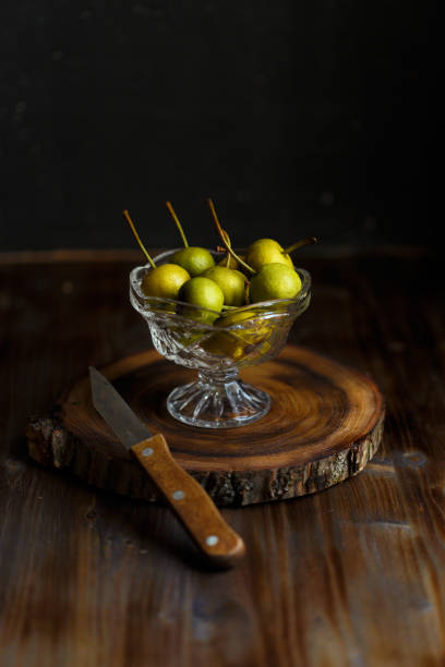 istock Wild pear in a glass bowl on a wooden dark background. Rustic concept 1052008904