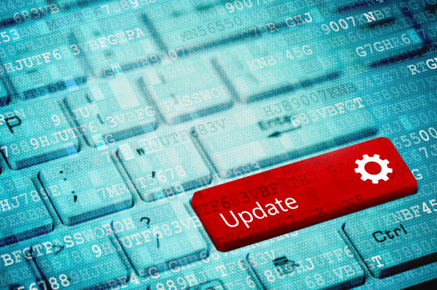 Red key with text Update and cogwheel icon on blue digital laptop keyboard stock photo