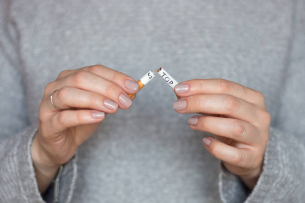 dejar el concepto de fumar cigarrillos. chica rompe un cigarrillo con la parada de palabras - anti cancer fotografías e imágenes de stock