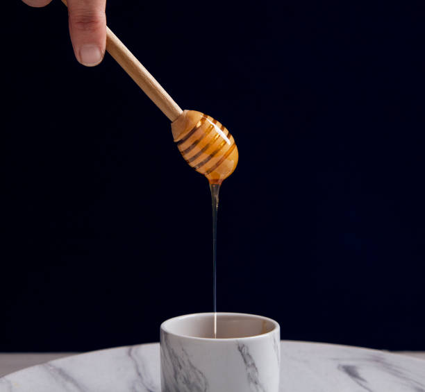 istock Honey dripping from a wooden honey dipper 1052048886