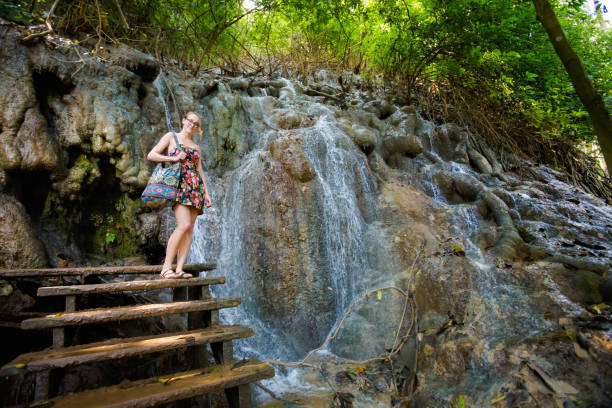 istock Girl on Kuang Si waterfall 1052049008