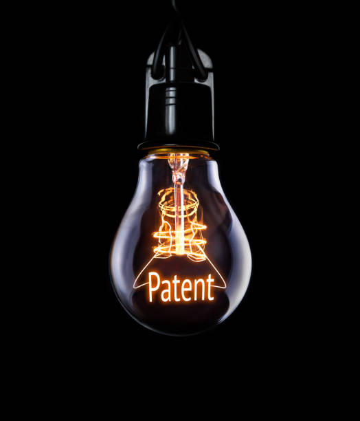 Lightbulb Patent concept. Hanging lightbulb with glowing Patent concept. global patent stock pictures, royalty-free photos & images